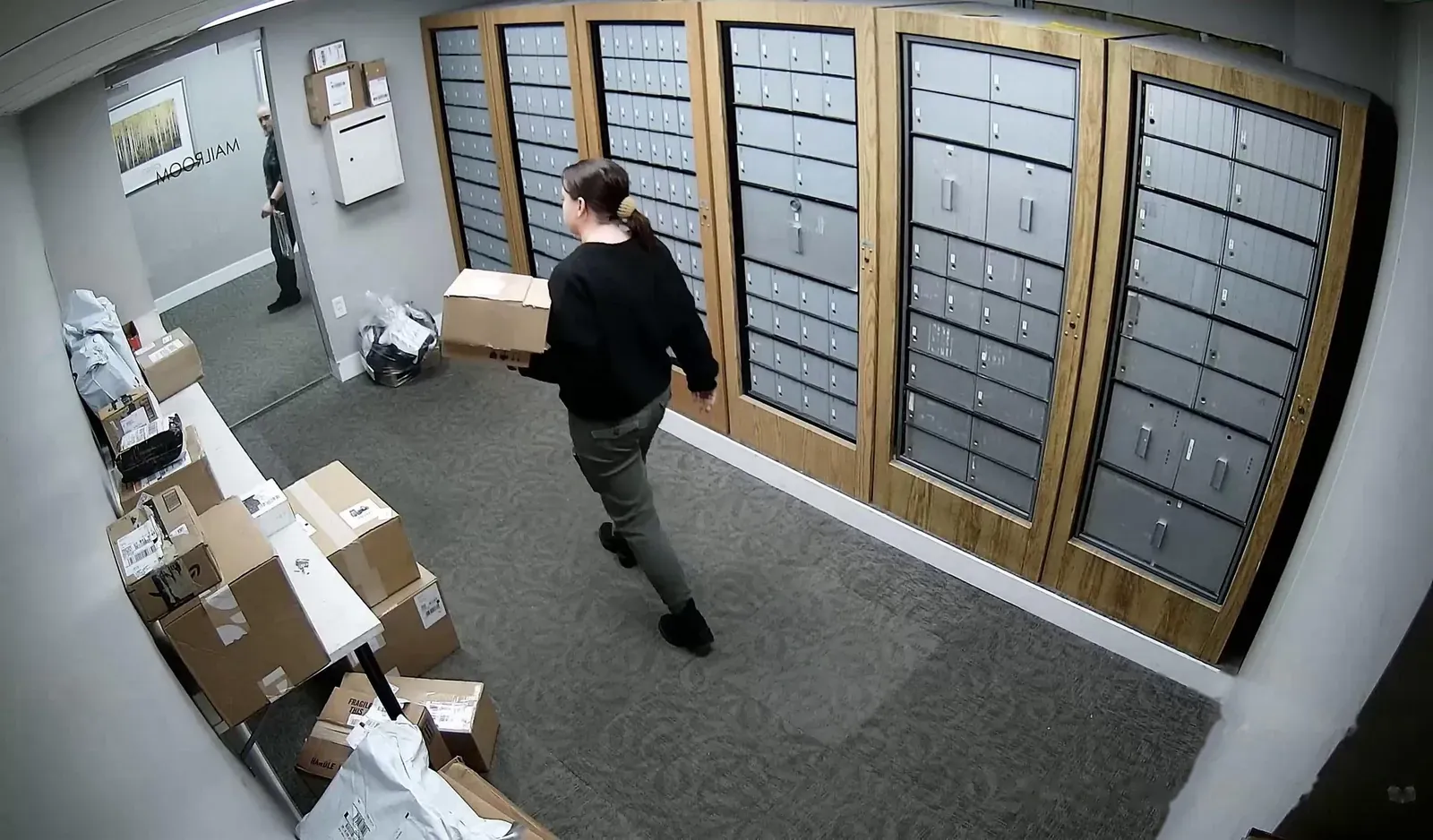 Mail room camera with a person carrying a package