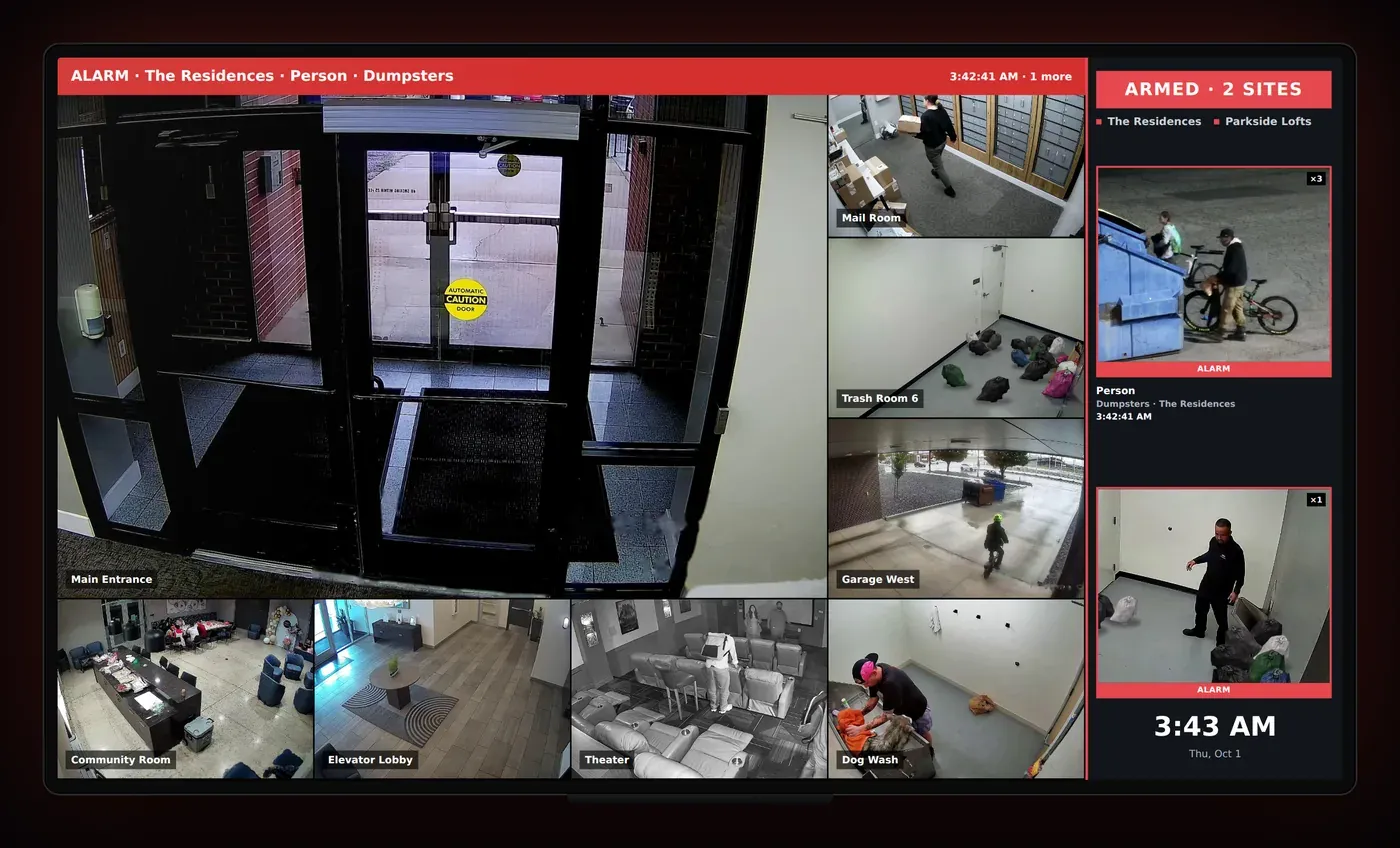 A TV showing a live camera wall with an alarm banner and alarm cards